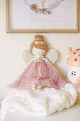 Load image into Gallery viewer, Mia Fairy Doll wearing a blush pink dress with golden wings and star accents, displayed on a cozy white blanket with soft lighting