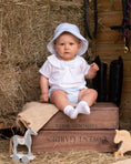 Load image into Gallery viewer, Baby boy wearing a blue outfit, sitting on hay surrounded by wooden toys and rustic decor.
